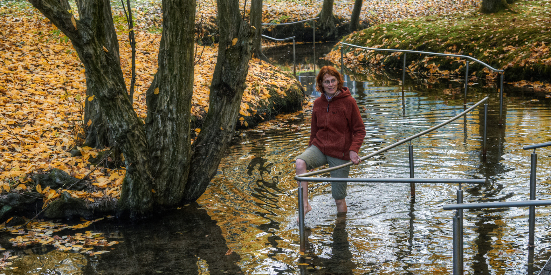 Eine Frau watet durch das Wasser im Kneipptretbecken
