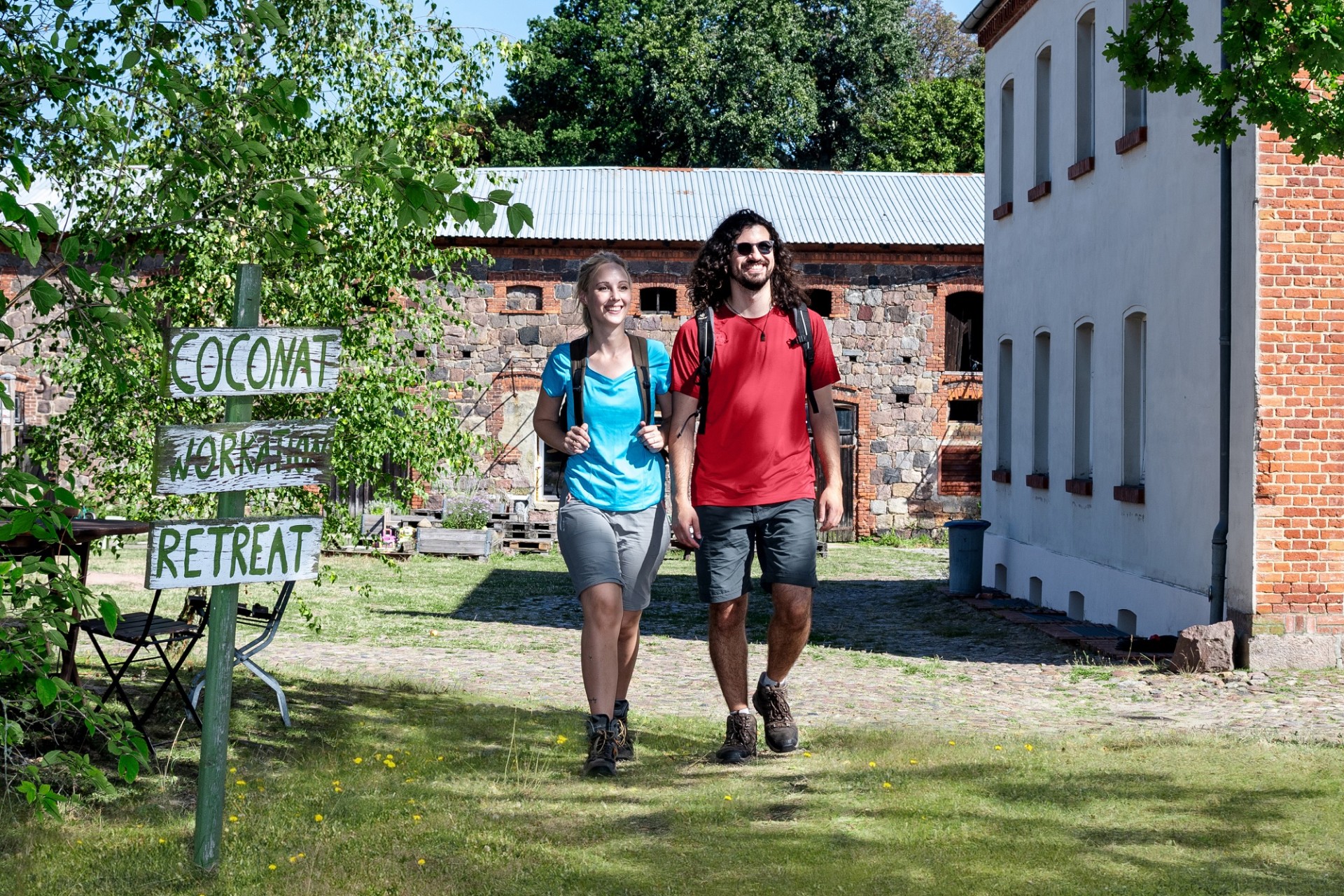 Ein junges Paar wandert über einen historischen Hof