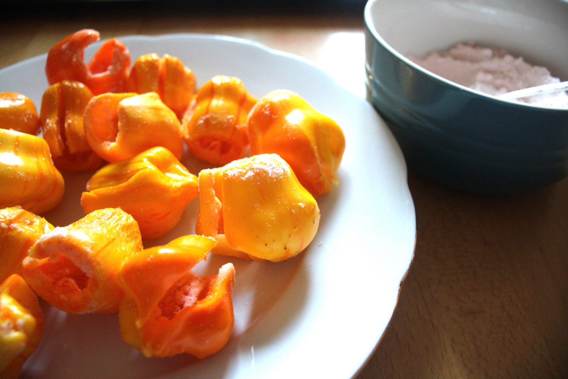 Gelb-orange-rote Chilis auf einem weißen Teller