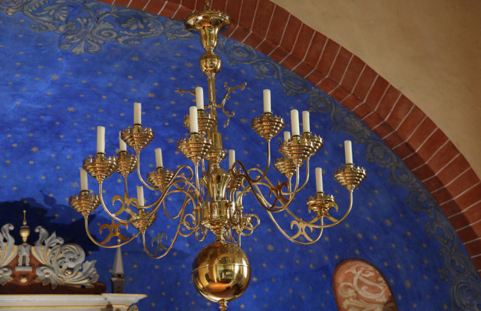 Goldener Kronleuchter mit Sternenhimmel im Hintergrund in der Kirche von Rädigke