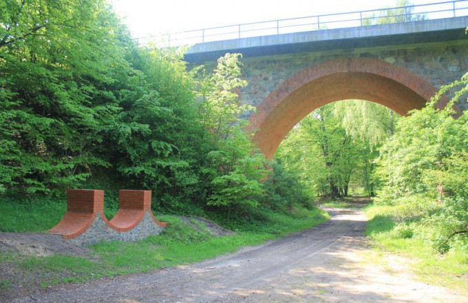 Blick auf eine Feldsteinbrücke mit Ziegelfassung, daneben ein kleiner Zwilling auf dem Rücken liegend