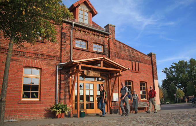 Eine Wandergruppe vor einem historischen Backsteingebäude