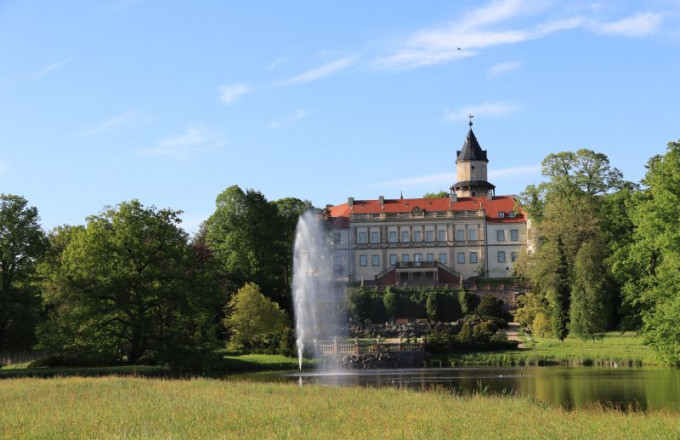 Blick über den Schlossparkteich mit Fontäne auf das Schloss Wiesenburg