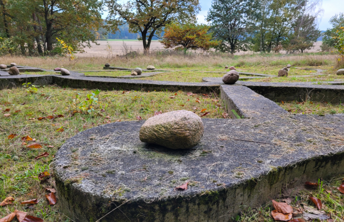 Betonpfade auf der Wiese mit Feldsteinen darauf