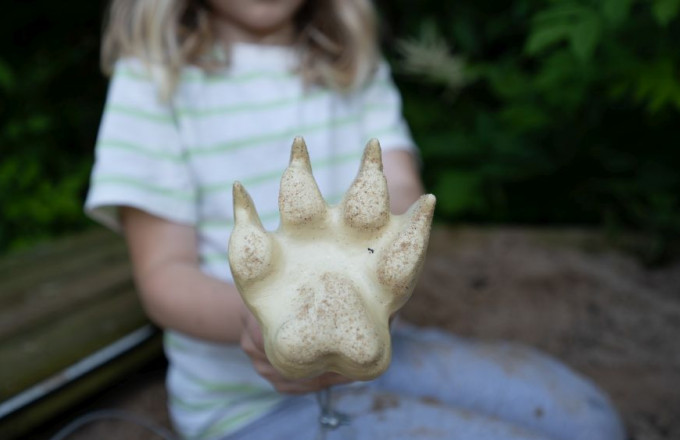 Ein Kind zeigt einen Spurenstempel in die Kamera