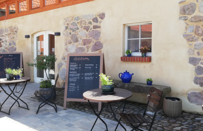 Bistro-Tische vor sanierter Hausfassade