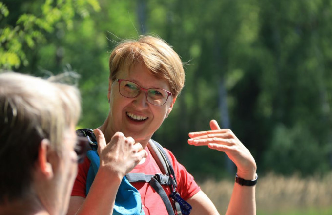 Eine Frau erzählt begeistert und unterstreicht das mit den Händen.