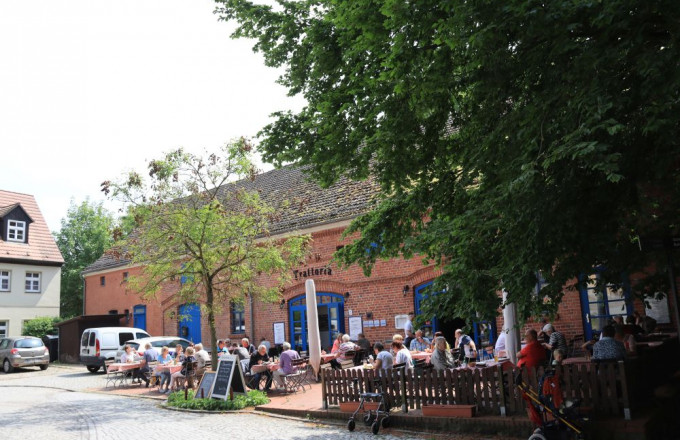 Außengastronomie vor einem historischen Backsteinbau