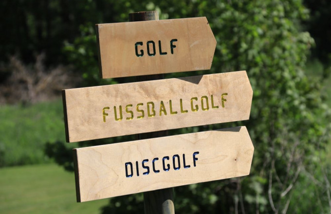 Holz-Hinweisschilder auf denen Golf, Fussballgolf und Discgolf geschschrieben steht