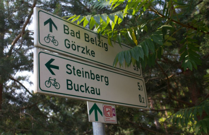 Ein Hinweisschild für Radfahrer zeigt, wo es nach Bad Belzig, Görzke, Steinberg und Buckau geht