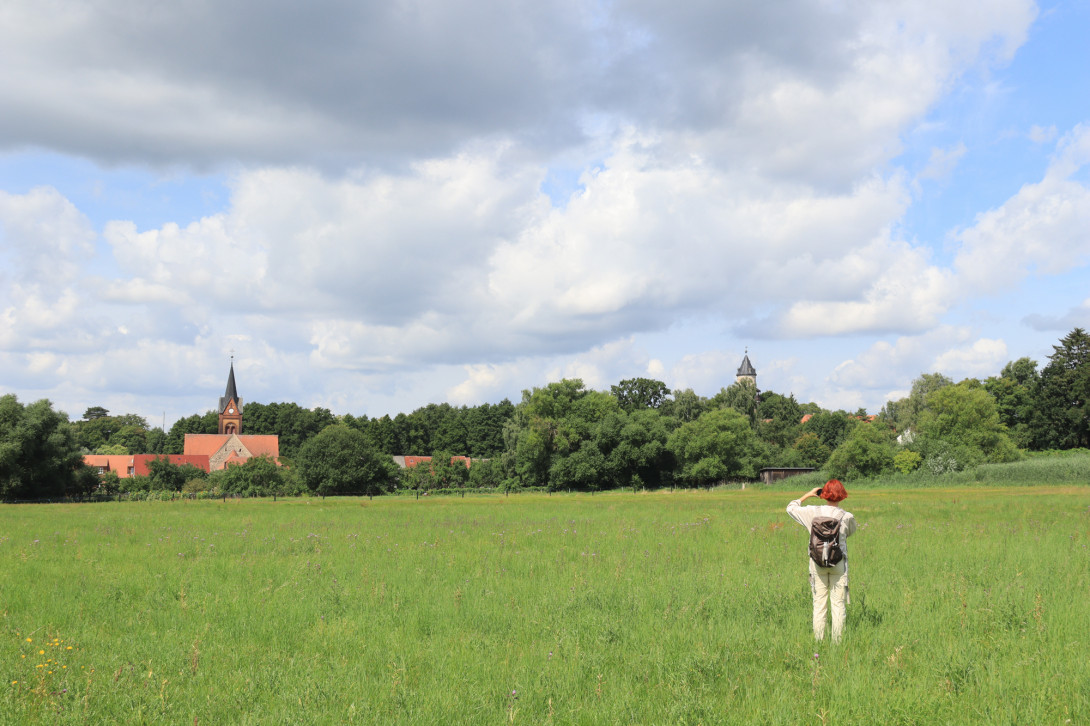 Wanderin betrachtet AR-Kunstwerk auf einer Wiese in Wiesenburg, Foto: Bansen-Wittig